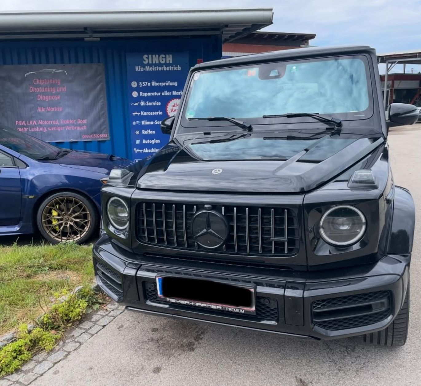 Schwarzer Mercedes-AMG G 63 vor der Werkstatt in Strau
